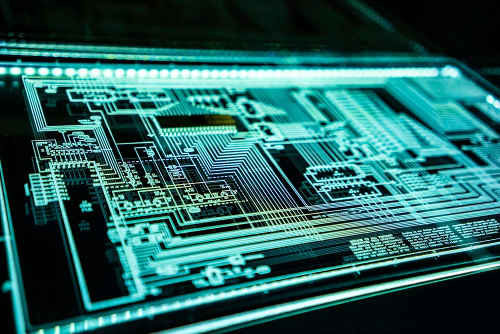 Close-up of a glowing teal circuit board, the kind of silicon that sits inside an RFID tag chip
